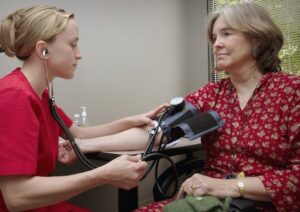 a nurse take an older woman's blood pressure